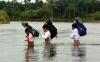 危险的游戏 印尼苏门答腊岛的孩子们涉水过河