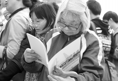 清华大学2014高考咨询会上，一位手提拐杖白发苍苍的老奶奶在查阅资料。