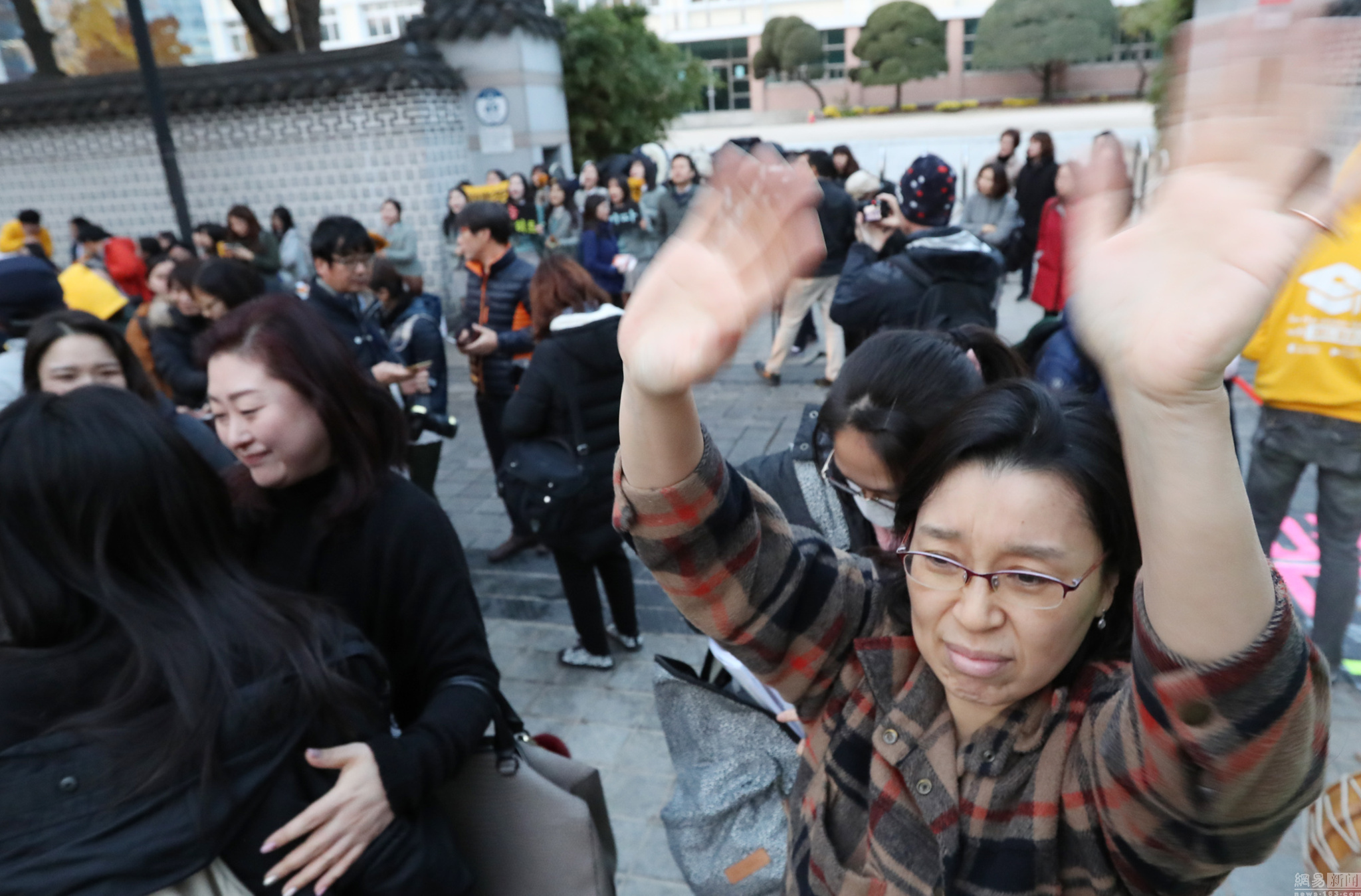 当地时间11月17日，韩国一年一度的高考（韩文名为大学修学能力考试，简称“修能”）拉开帷幕，考生的家长及学妹学弟在考场外为考生助威加油。图/视觉中国