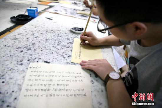 5月21日，在陕西咸阳师范学院于右任书法学院内，数十名大学生手执毛笔用小楷书写着家书。自2016年以来，该院256名学生每逢母亲节、父亲节便用小楷书写家书一封，如今学院要求学生每月写一封。该院开展此项活动，旨在开展孝文化感恩教育，还原古代文人部分日常生活形式，为学生营造一个高雅的学习氛围。 张远 摄