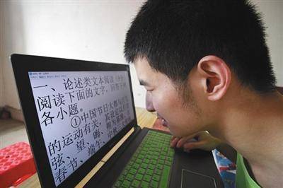 因为几乎全盲，王宠需要把字号调大，眼睛贴近屏幕才能看清字。受访者供图。图片来源：新京报