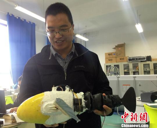 图为兰州交通大学机器人创新创业基地负责人李宗刚展示机器鱼。 徐雪 摄