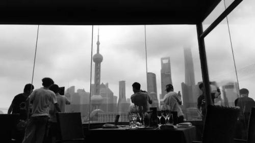 “手机摄”上海外滩罗斯福色戒餐厅，大家透过窗户在拍摄清晨的东方明珠。