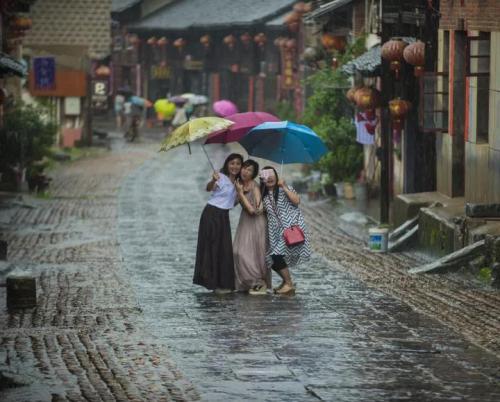 “相机摄”湖南永州市零陵老街，三位美女在雨中的老街玩自拍。