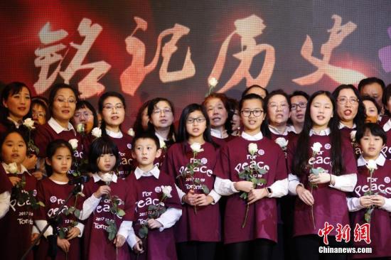 当地时间12月9日，加拿大安大略省各界华人共同举办的“南京大屠杀80周年追思会”在多伦多举行。来自华人社区及其他多个族裔社区的逾千名代表参加此次主题为“铭记历史，祈愿和平”的追思会。图为社区人士与孩子们在追思会上合唱《让世界充满爱》。 记者 余瑞冬 摄